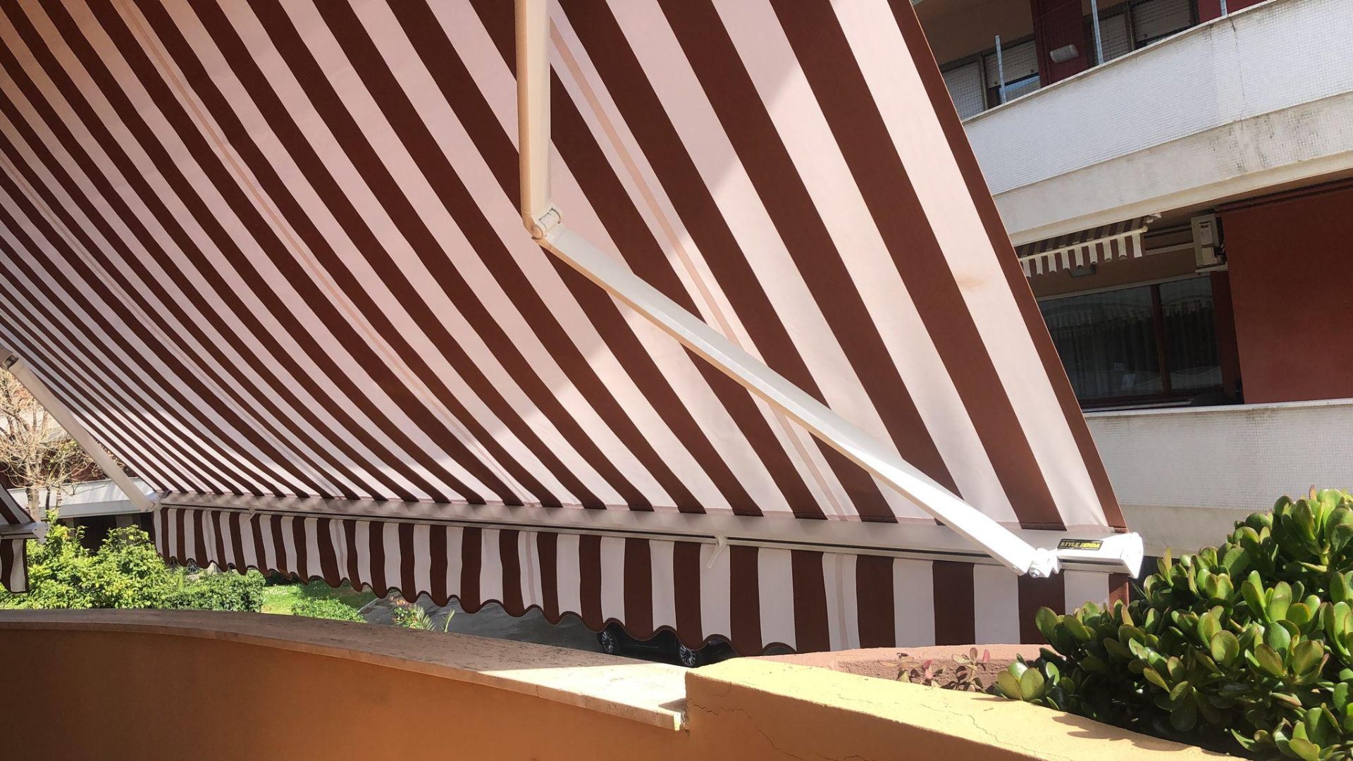 Tenda a bracci a strisce bianche e marroni