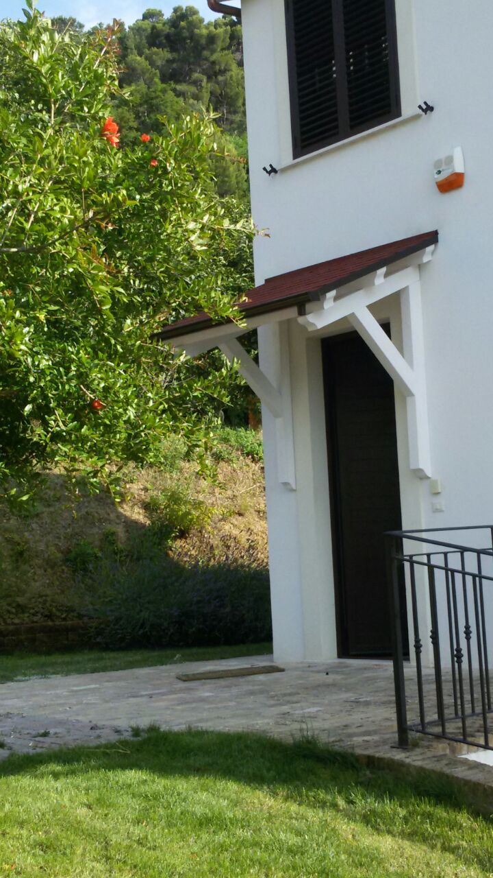 Tettoia in legno bianca su porta d'ingresso